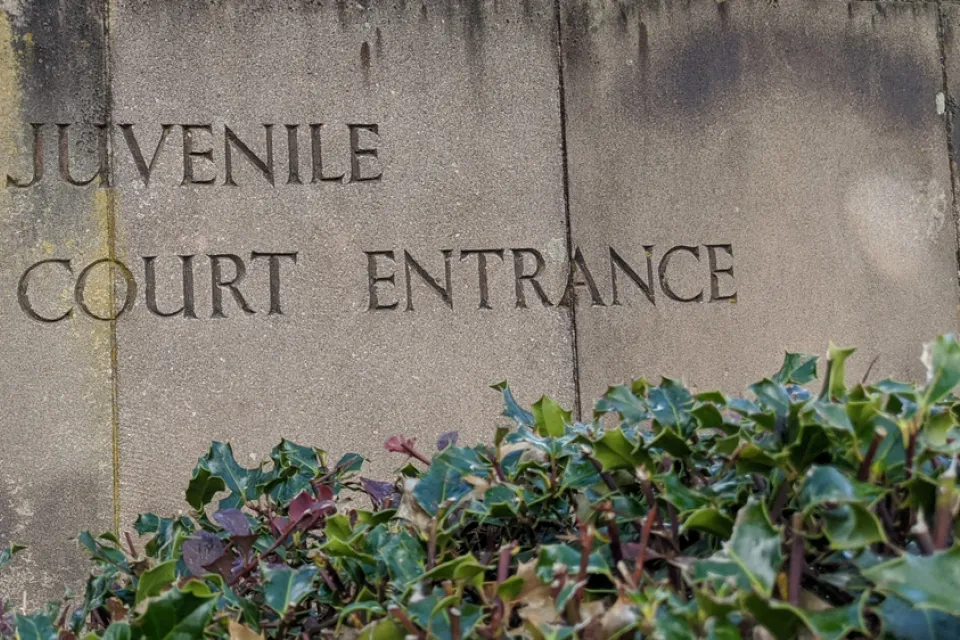 Weathered stone slabs with the words Juvenile Court Entrance engraved into it.